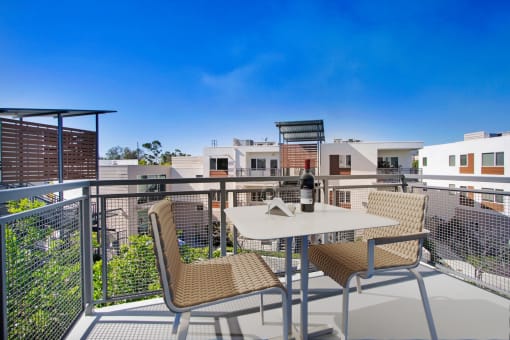 a table and chairs on a balcony with a bottle of wine