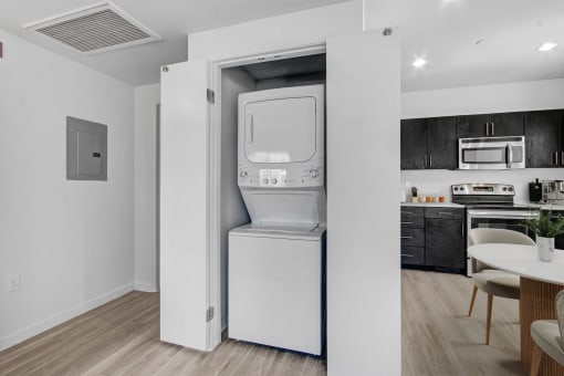 a white washer and dryer unit in a room with a dining room table