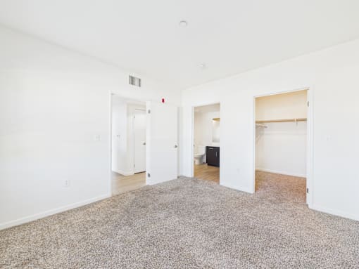 A room with white walls and a grey carpet.