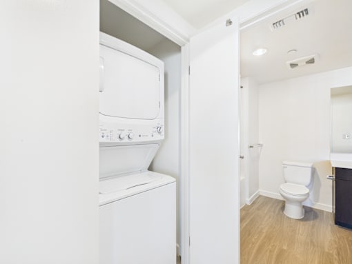 A white washing machine is in a small laundry room.