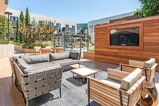 A wooden outdoor furniture set is on a patio.