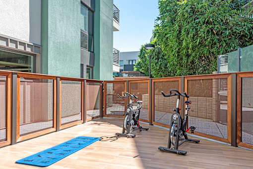 A gym with exercise bikes and a blue mat.