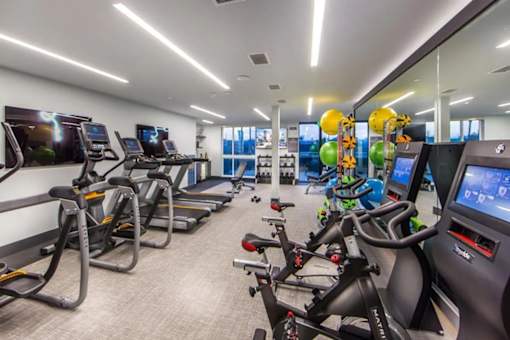A gym with treadmills and stationary bikes.