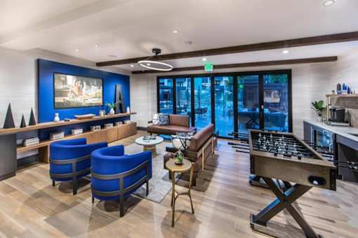 A modern living room with a foosball table and a fireplace.