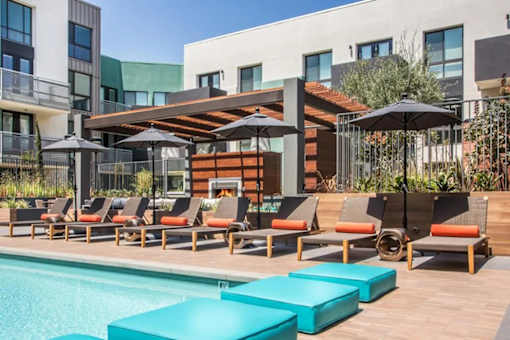A poolside area with lounge chairs and umbrellas.