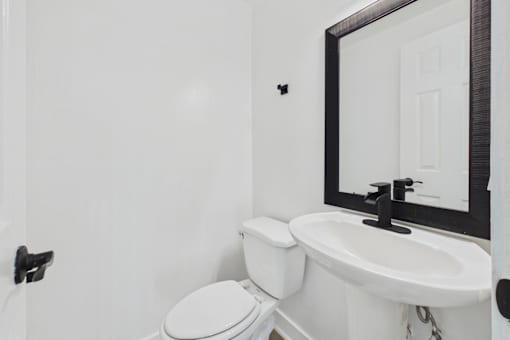 A white toilet and sink in a bathroom.