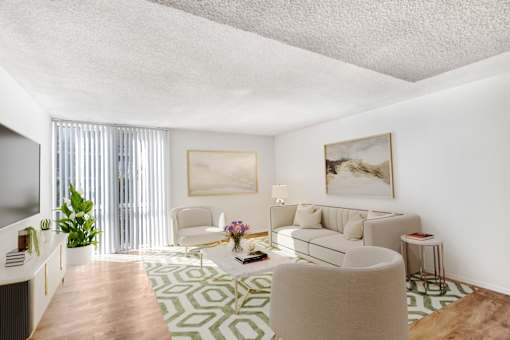 A living room with a white couch, a green and white rug, and a painting on the wall.