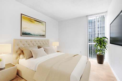 A bedroom with a large bed and a painting on the wall.