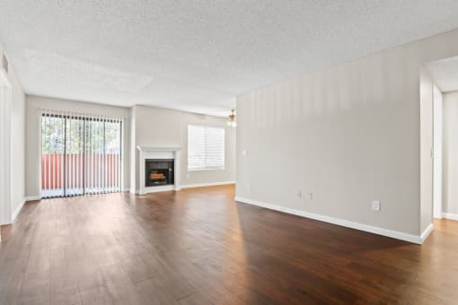the spacious living room with wood flooring and a fireplace