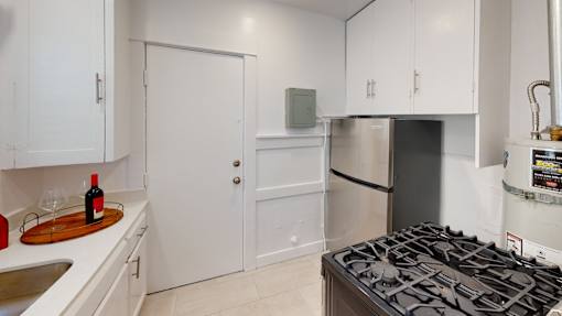 A kitchen with white cabinets and a black stove top.