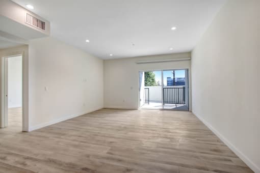 a bedroom with hardwood floors and white walls
