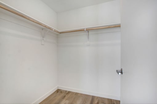 an empty room with white walls and a wooden floor
