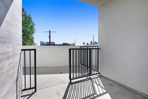 a balcony with a black gate and a tree in the background
