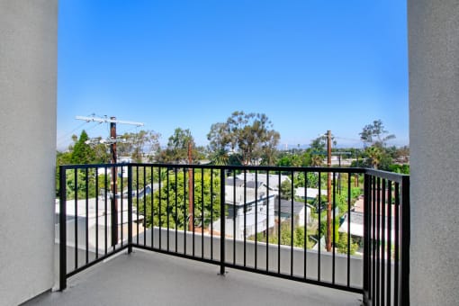 a balcony with a black railing and a view of a parking lot