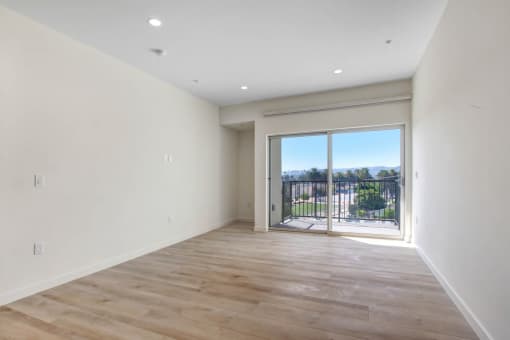 a bedroom with a sliding glass door and hardwood floors