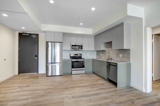 a kitchen with gray cabinets and stainless steel appliances