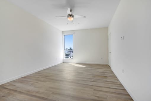 a bedroom with hardwood floors and white walls
