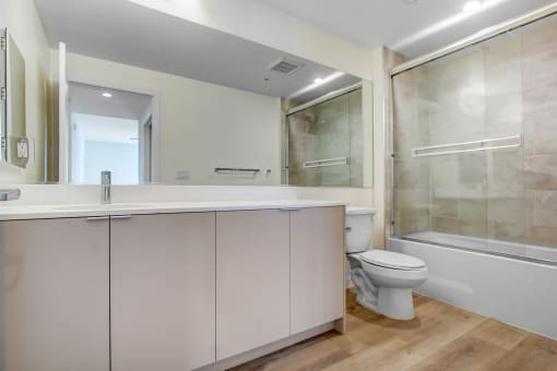 a bathroom with a toilet sink mirror and bathtub