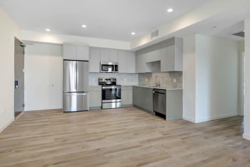 a kitchen with stainless steel appliances and a wooden floor