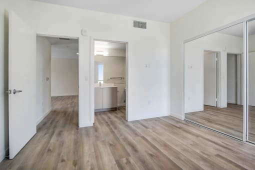 a bedroom with hardwood floors and white walls