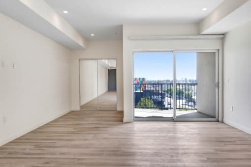 a bedroom with a medium sized window and a door that leads to a balcony