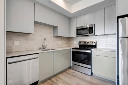 a kitchen with white cabinets and stainless steel appliances