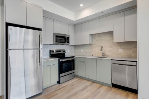 a kitchen with white cabinets and stainless steel appliances