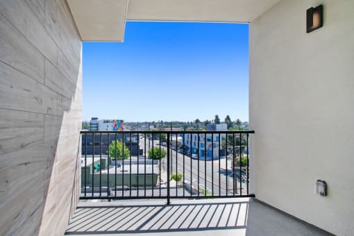 a balcony with a black railing and a view of a parking lot