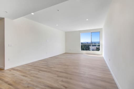 a bedroom with hardwood floors and a large window