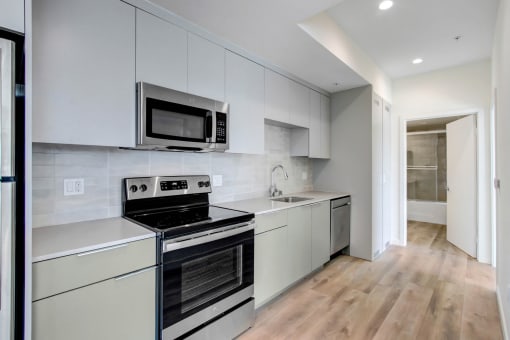 a kitchen with white cabinetry and stainless steel appliances