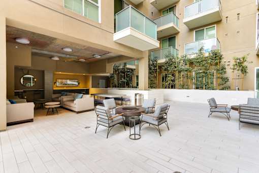 A patio with a table and chairs is surrounded by apartment buildings.