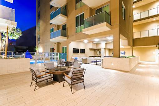 A patio with a table and chairs is surrounded by apartment buildings.