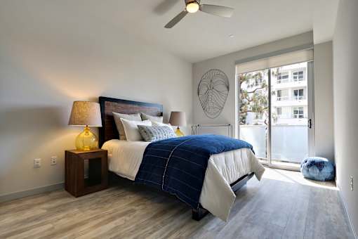 A bedroom with a bed, nightstand, and a ceiling fan.