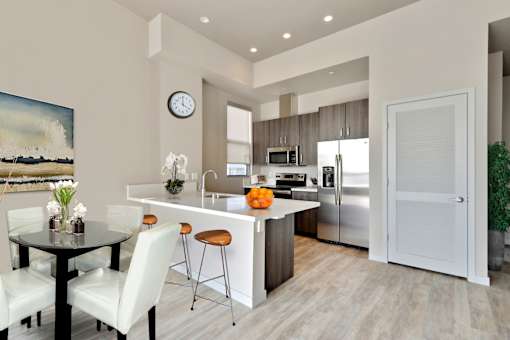 A modern kitchen with a dining table and chairs.