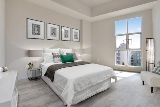 A bedroom with a large bed and a view of the city.