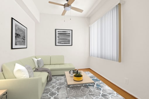 a living room with white walls and a ceiling fan