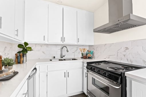 a kitchen with white cabinetry and a stainless steel stove top oven