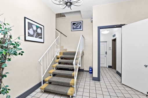 a picture of a hallway with a staircase and a chandelier