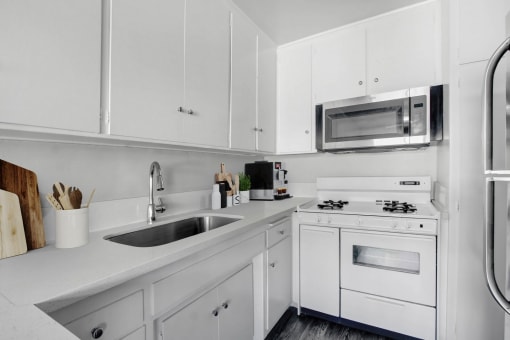 a kitchen with white cabinets and a sink and a microwave