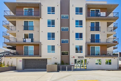 Apartment building with balconies and a garage door.