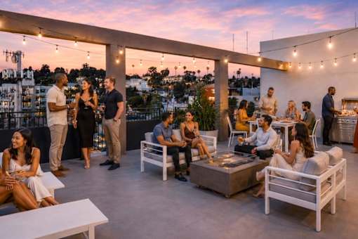 A group of people are gathered on a rooftop terrace.