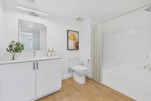 A white bathroom with a toilet, sink, and bathtub.