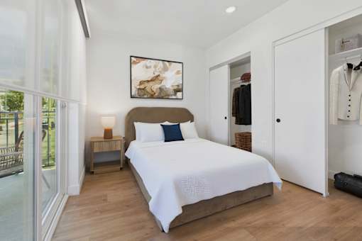 A bedroom with a large bed and a painting on the wall.