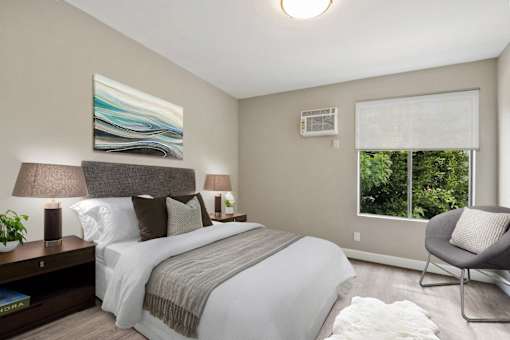 Bedroom with wood-inspired floors, sliding window