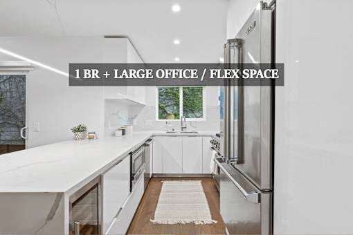 A modern kitchen with a large island and stainless steel appliances.