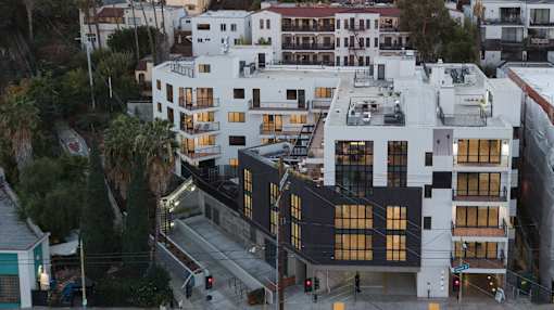 A modern building with black and white exterior is seen from an aerial perspective.