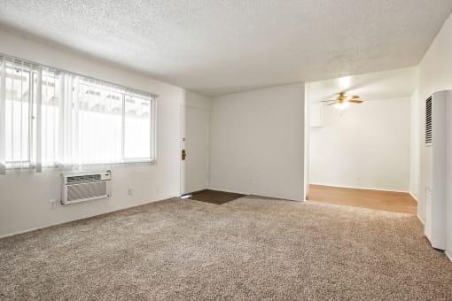 Living room with air conditioning, carpeted flooring , ceiling fan in dining area