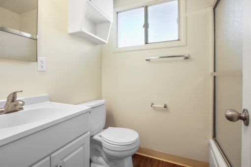 Bathroom with shower and tub combo at the right, single vanity with white cabinet