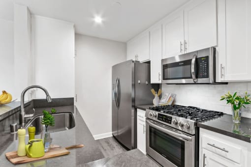A modern kitchen with a stainless steel refrigerator, oven, and microwave.