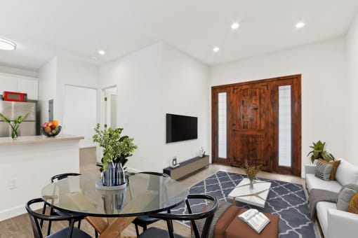 a living room with a glass table and chairs